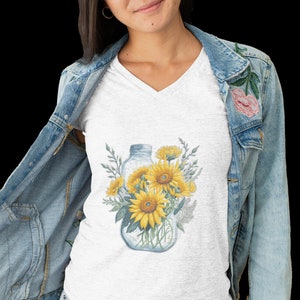 May include: A white t-shirt with a graphic of a glass jar filled with sunflowers and greenery.