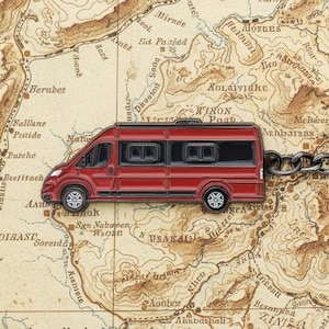 May include: A red camper van keychain with a silver chain and ring, set against a vintage map background. The keychain is a miniature replica of a recreational vehicle, perfect for travel enthusiasts.