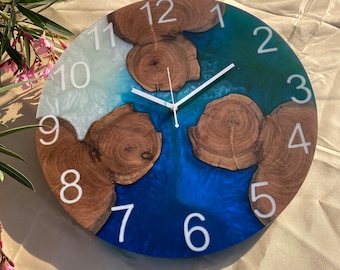 May include: A round, blue, white, and brown resin clock with white numbers 1 through 12. The clock has a white hand and a white second hand.