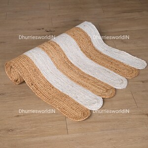 May include: A brown and white striped jute rug with a wavy edge. The rug is made of natural fibers and has a rustic look.
