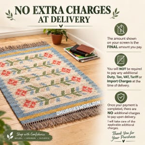 May include: A rectangular area rug with a cream-colored base featuring a repeating pattern of green stems and red flowers. The rug has blue and yellow borders and brown fringe on the ends. Text on the rug reads DHURRIESWORLDIN.