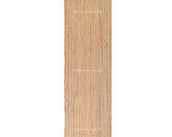 Puede incluir: Una alfombra de fibra natural hecha de yute, un material sostenible y duradero. La alfombra tiene un color marrón claro y una textura tejida. Es una alfombra rectangular de forma larga y estrecha.