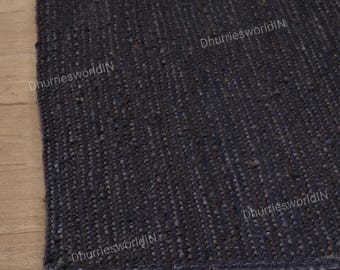 May include: Close-up of a dark blue jute rug with a woven texture. The rug has a frayed edge and the text "DhurriesworldIN" is visible in the image.