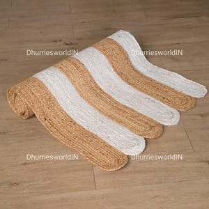May include: A brown and white striped jute rug with a wavy edge. The rug is made of natural fibers and has a rustic look.