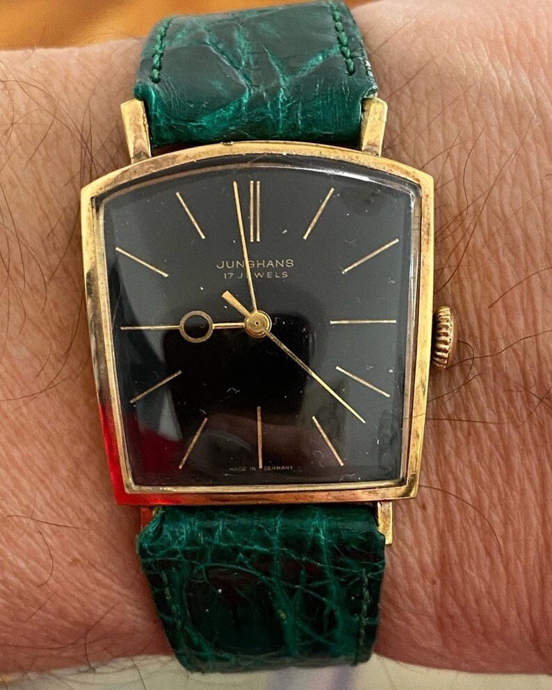 Linterna Junghans extremadamente rara de la década de 1950, chapada en oro, con caja de depósito, movimiento de cuerda manual, J84/S, esfera negra, funciona imagen 1