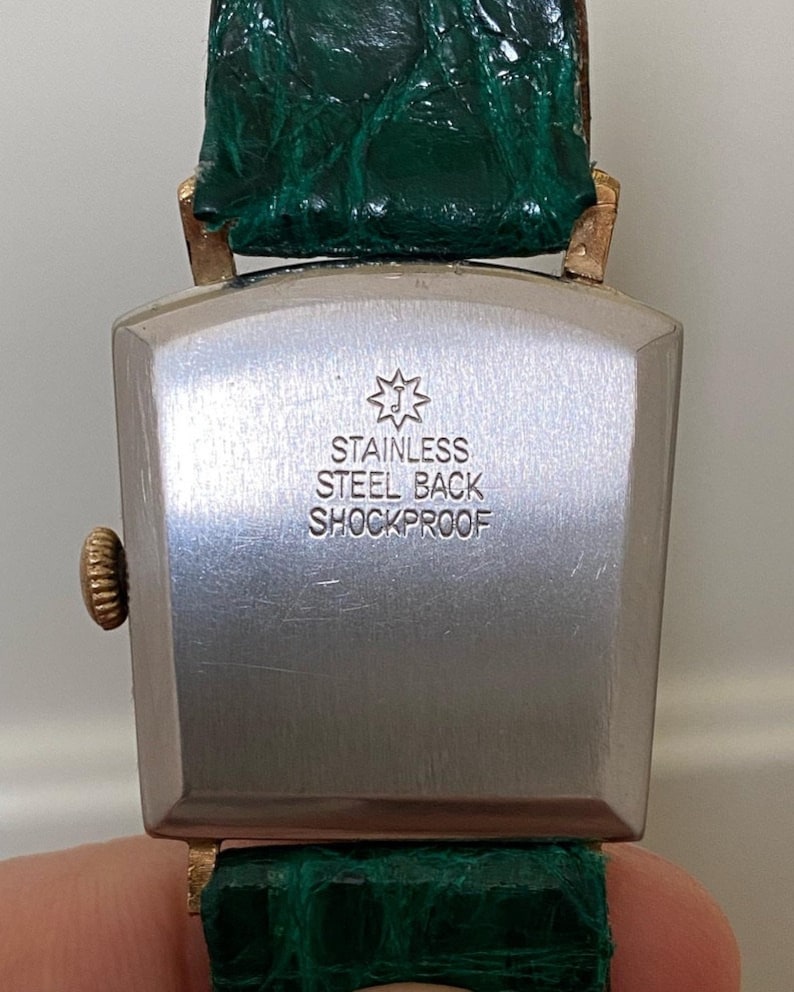 Linterna Junghans extremadamente rara de la década de 1950, chapada en oro, con caja de depósito, movimiento de cuerda manual, J84/S, esfera negra, funciona imagen 2