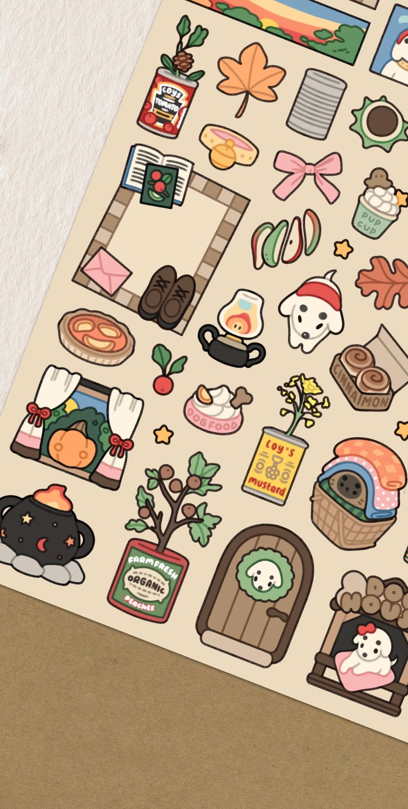 May include: A sheet of decorative stickers featuring various illustrated objects. The stickers include a pumpkin, a dog, a pie, a can of mustard, a book, a bow, and a door with a dog-shaped wreath. The color palette is primarily beige, brown, and orange.