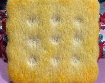 May include: A yellow felt square with a textured surface and a pattern of raised circles. The felt is soft and fluffy.