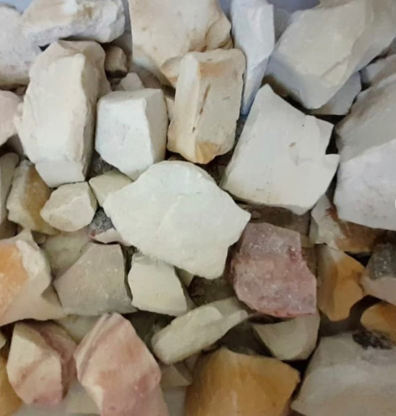 Peut inclure: Gros plan sur un tas de pierres blanches, beiges et roses. Les pierres sont de diff&eacute;rentes tailles et formes.