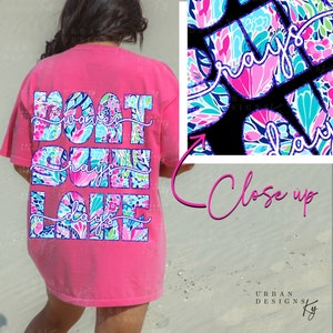 May include: A hot pink t-shirt with the words "Boat Waves Gray Lake Days" in a colorful floral pattern. A close-up shows the floral pattern with the word "rays". The shirt is a casual style.