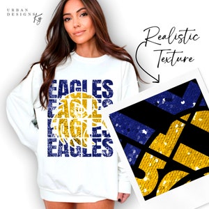May include: White sweatshirt with the word "EAGLES" repeated four times in a stacked design. The word is in a blue and gold color scheme with a basketball graphic in the center. A close-up of the design shows a realistic texture of sequins.
