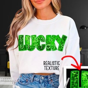 May include: White sweatshirt with the word "LUCKY" in green glitter letters. The glitter is a realistic texture.