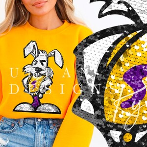 May include: A yellow sweatshirt with a cartoon rabbit wearing a purple and gold basketball jersey. The rabbit is holding a basketball and has a serious expression on its face. The sweatshirt has the text "URBAN DESIGN" printed on it.