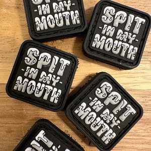 May include: Five black square patches with white text that reads "SPIT -IN MY- MOUTH" in a dripping font.