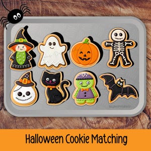 May include: A set of eight Halloween-themed cookies on a gray tray, including a witch, ghost, pumpkin, skeleton, skull, black cat, monster, and bat. A black spider is in the top left corner. The text "Halloween Cookie Matching" is at the bottom.