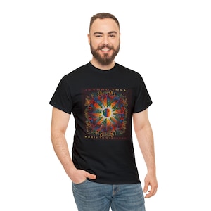 May include: Black t-shirt with a colorful graphic of a mandala with the text "Jethro Tull" and "Roots to Branches" printed on the front.