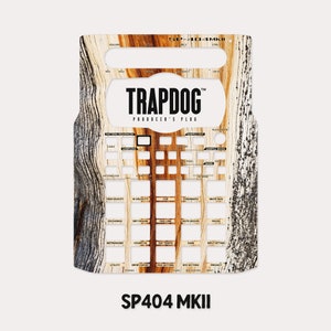 Puede incluir: Una piel con patrón de veta de madera para el sampler Roland SP-404 MKII, con el texto "TRAPDOG PRODUCER'S PLUG".