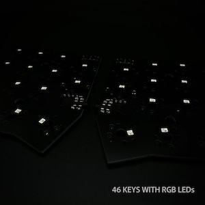 May include: Two black circuit boards with white LED lights. The boards are labeled "46 KEYS WITH RGB LEDs". The boards are set against a dark background.