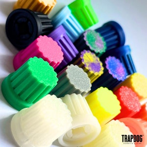 Peut inclure: Un ensemble d'objets cylindriques color&eacute;s avec des c&ocirc;t&eacute;s nervur&eacute;s et un dessus plat. Les objets sont de diff&eacute;rentes couleurs, notamment vert, rose, violet, bleu, jaune et blanc. L'image est bien &eacute;clair&eacute;e, mettant en valeur les teintes vives.