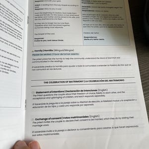 Op de afbeelding: Open boek met tekst in het Engels en Spaans. Secties omvatten evangelielezingen, homilie-instructies en intentieverklaringen voor een huwelijksceremonie. De pagina's zijn wit met zwarte tekst.