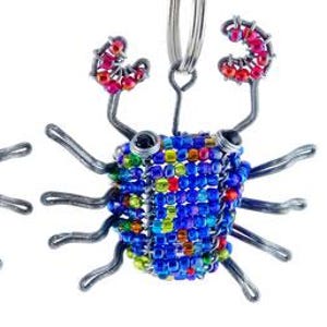May include: Two beaded crab keychains. One crab is multi-colored with red, yellow, and blue beads. The other crab is blue with red, yellow, and green beads. Both crabs have silver wire legs and claws, and black eyes.