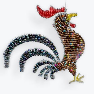 May include: A beaded rooster ornament with a red comb, brown body, and iridescent tail feathers. The rooster's beak and feet are yellow. The ornament is made of small, colorful beads strung together, creating a textured appearance.