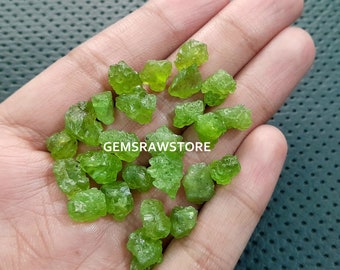 May include: A collection of small, rough, green peridot crystals. The crystals are various sizes and shapes, and have a natural, unpolished look.