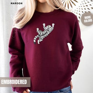 Climbing Cat Sweatshirt Embroidered Design Women Grey Tabby Kitten Pullover Top Novelty Animal Apparel Cozy Cotton Blend Soft Comfortable Fit Large Chest Detail Perfect Cat Mom Gift Pet Parent Present Birthday Occasion Cat Lover Essential
