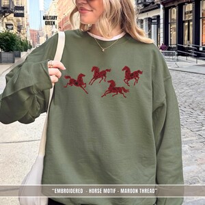 Woman wearing military green embroidered horse sweatshirt styled for everyday casual wear