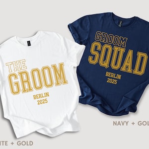 Peut inclure: Deux t-shirts avec un imprim&eacute; dor&eacute; sur fond blanc et bleu marine. Le t-shirt blanc dit "The Groom" avec "Berlin 2025" en dessous. Le t-shirt bleu marine dit "Groom Squad" avec "Berlin 2025" en dessous.