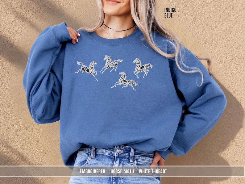 Indigo blue sweatshirt with white & black embroidered horses styled for a relaxed unisex look