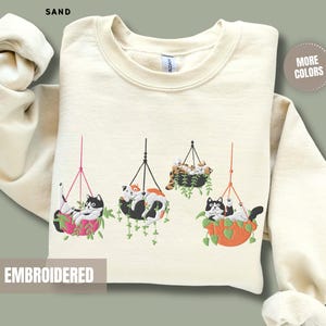 猫の刺繍入り植物柄スウェットシャツ。猫ママや植物愛好家のための快適なクルーネック。母の日ギフト。ホリデーセーター。愛らしい猫柄ジャンパー。