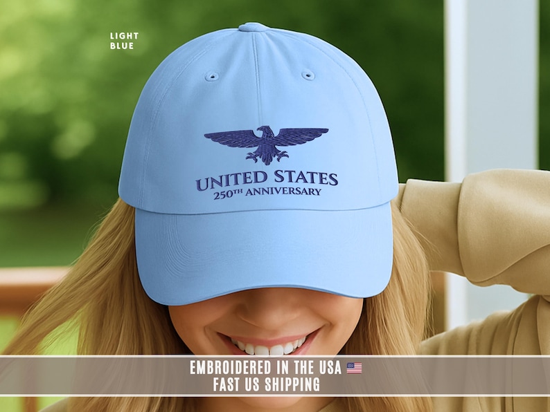 Light blue embroidered United States 250th anniversary baseball cap with eagle emblem, worn outdoors in natural light.