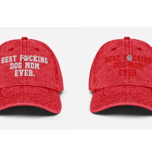 Peut inclure: Casquette de baseball en coton vintage rouge d&eacute;lav&eacute; avec le texte brod&eacute; en blanc "Best F*cking Dog Mom Ever." et une empreinte de patte.