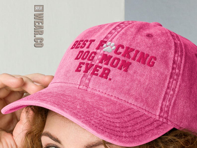 Peut inclure: Casquette de baseball rose avec le texte "Best Dog Mom Ever." brod&eacute; en rose avec une empreinte de patte blanche.