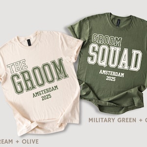 Peut inclure: Deux t-shirts, l'un cr&egrave;me et l'autre vert olive, avec le texte "The Groom" et "Groom Squad" imprim&eacute; dessus. Les deux t-shirts ont le texte "Amsterdam 2025" imprim&eacute; sous le texte principal.