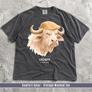 Pepper Comfort Colors GRUMPH albino buffalo trump look alike graphic T-shirt flat lay on grunge concrete background.