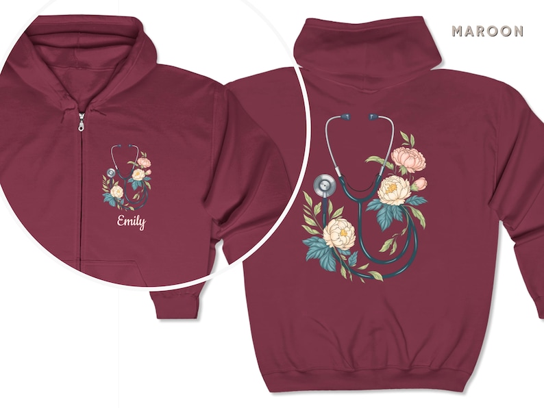 Pu&ograve; includere: Felpa con cappuccio con zip color bordeaux con uno stetoscopio e un design floreale. Il testo "Emily" &egrave; ricamato sulla parte anteriore della felpa.