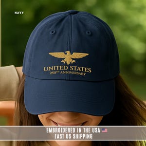 Navy blue embroidered United States 250th anniversary cap with gold eagle, worn close up to show embroidery quality.