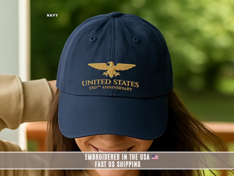 Navy blue embroidered United States 250th anniversary cap with gold eagle, worn close up to show embroidery quality.