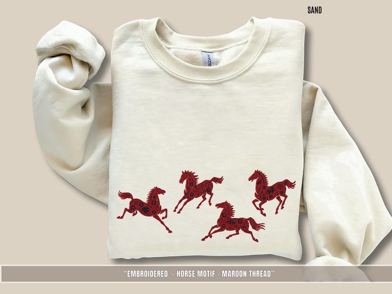Beige Sand sweatshirt folded to show maroon embroidered horses across the chest