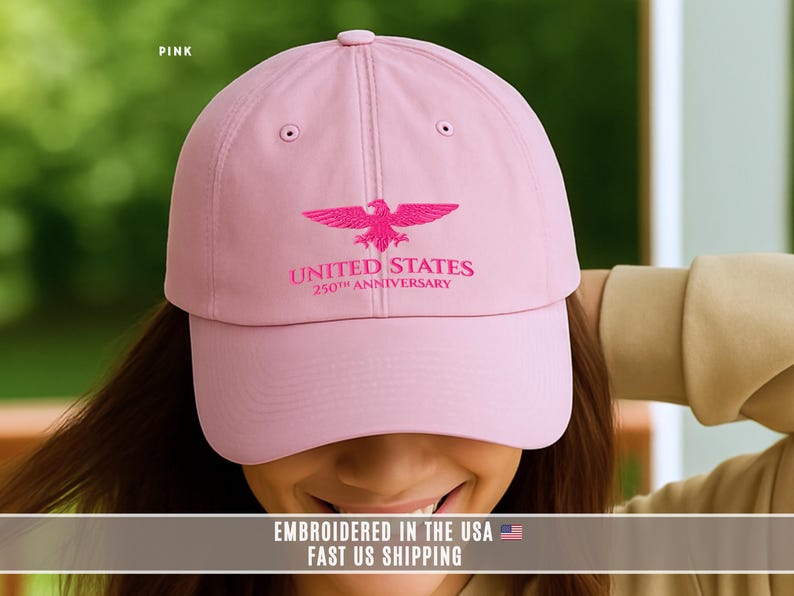 Pink embroidered United States 250th anniversary baseball cap with eagle design, casual lifestyle photo worn by model.