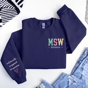 May include: Navy blue sweatshirt with the text "MSW - JENNIFER" on the front and the text "advocate support empower" on one sleeve.