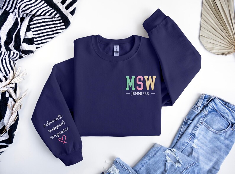 May include: Navy blue sweatshirt with the text "MSW - JENNIFER" on the front and the text "advocate support empower" on one sleeve.