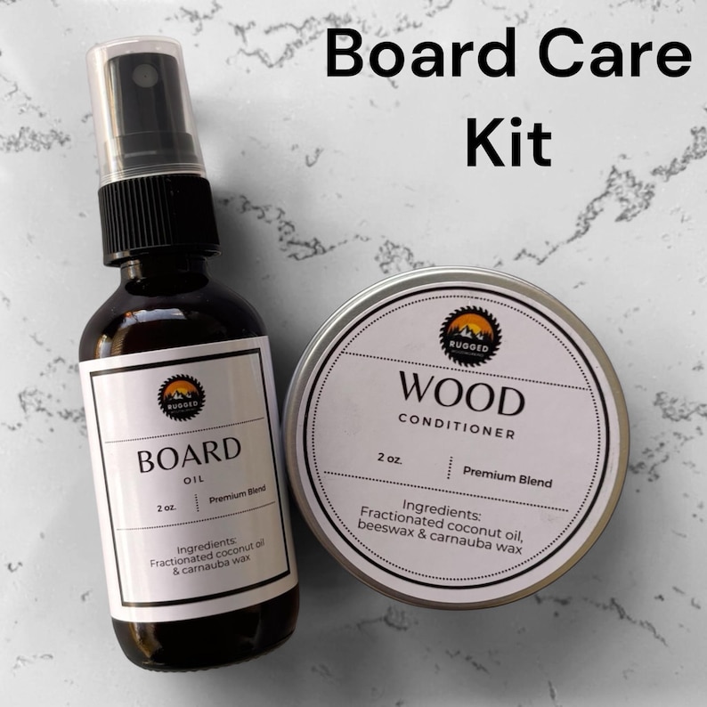 May include: A board care kit consisting of a dark amber glass spray bottle labeled Board Oil and a round metal tin labeled Wood Conditioner. Both containers feature white labels with black text, a logo, and a 2 oz. volume specification.