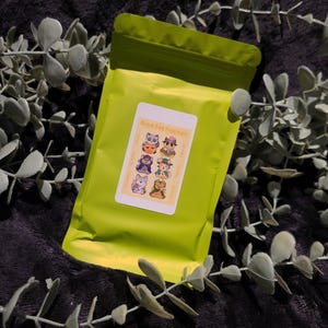 May include: A yellow resealable pouch with a sticker that says "Blind Bag Keychain". The sticker features a cartoon illustration of six different animal characters.