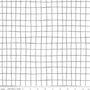May include: White fabric with a black grid pattern. The grid lines are slightly uneven, creating a hand-drawn look. A ruler is at the bottom, showing measurements in inches.