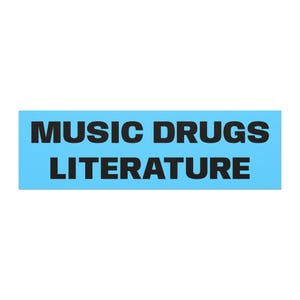 May include: A rectangular sticker with a light blue background featuring the black text MUSIC DRUGS LITERATURE arranged in two lines. The font is a bold, sans-serif typeface that spans the width of the sticker, creating a clear and legible design.