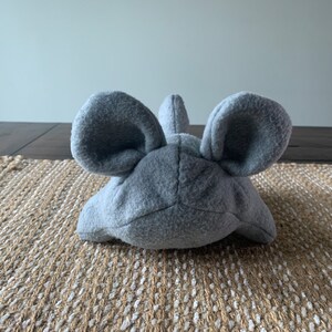 May include: A gray plush toy shaped like a mouse with large ears.