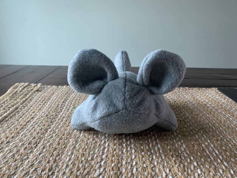 May include: A gray plush toy shaped like a mouse with large ears.